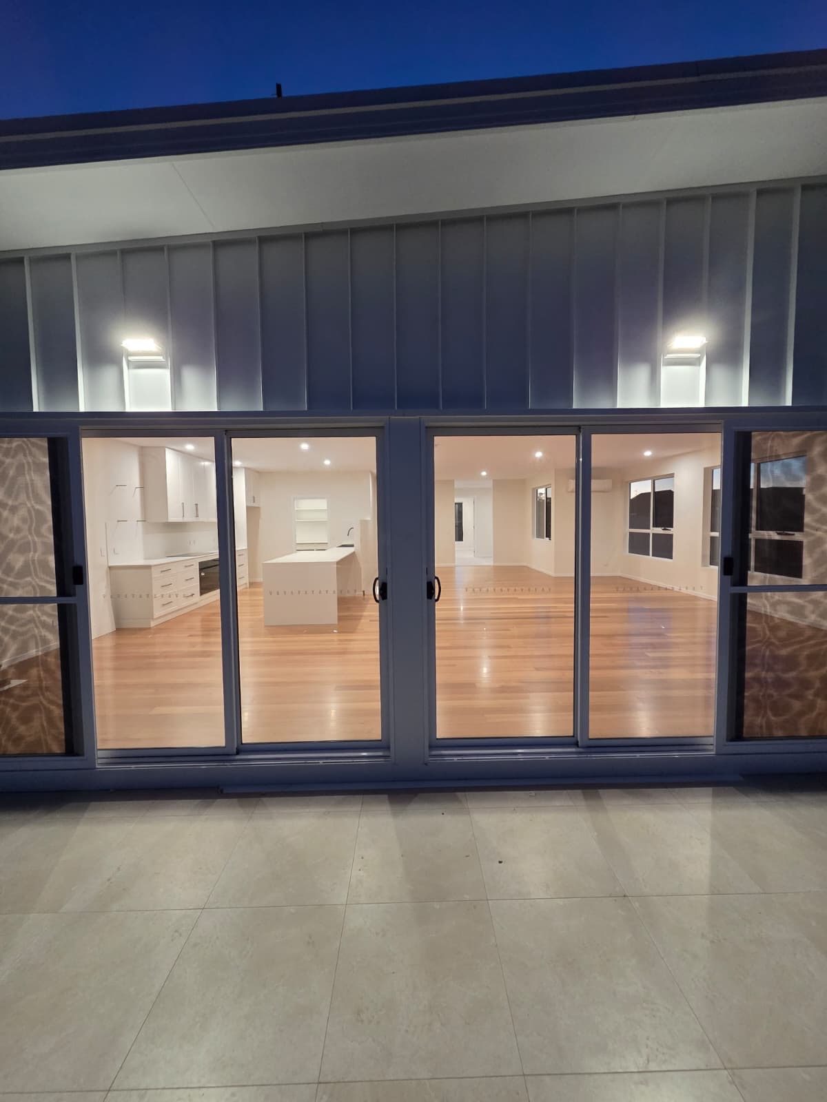 Exterior up/down wall lights and open-plan living lighting installed by MVS Connect on a new home in North-West Tasmania